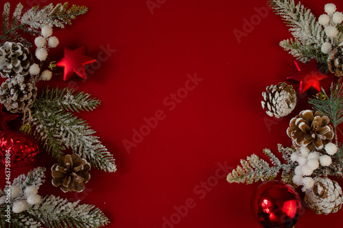 red background, Christmas tree branches, cones, Christmas balls. festive background. new year