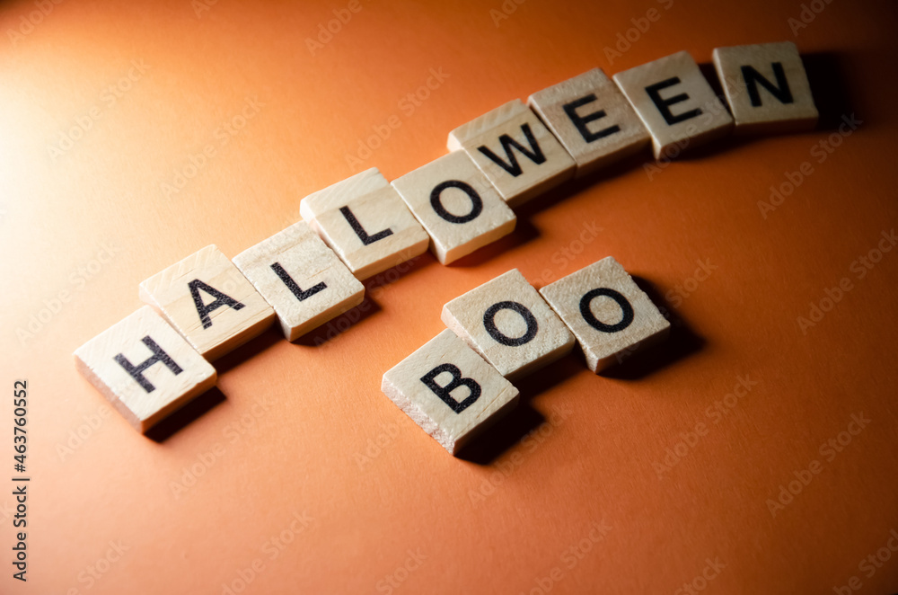 Obraz premium Inscription Halloween Boo outlined on orange background with copy space. Selective focus on Lettering Halloween. Celebration concept.