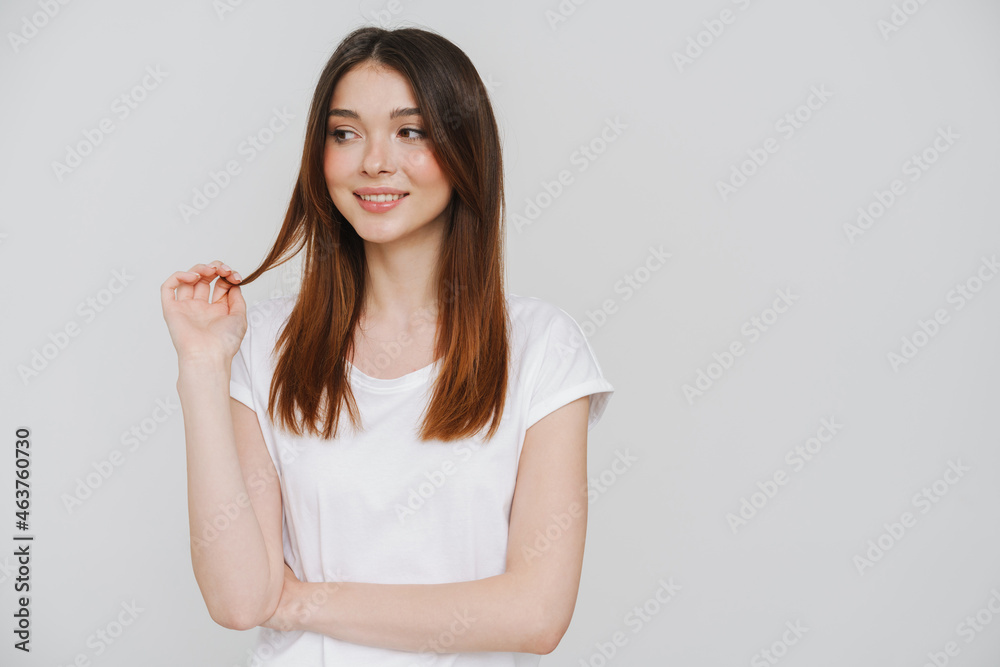 Young ginger woman holding her hair and looking aside Young ginger woman holding her hair and looking aside