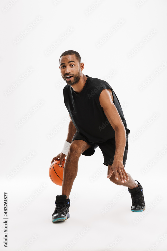 Young black sportsman playing basketball while working out