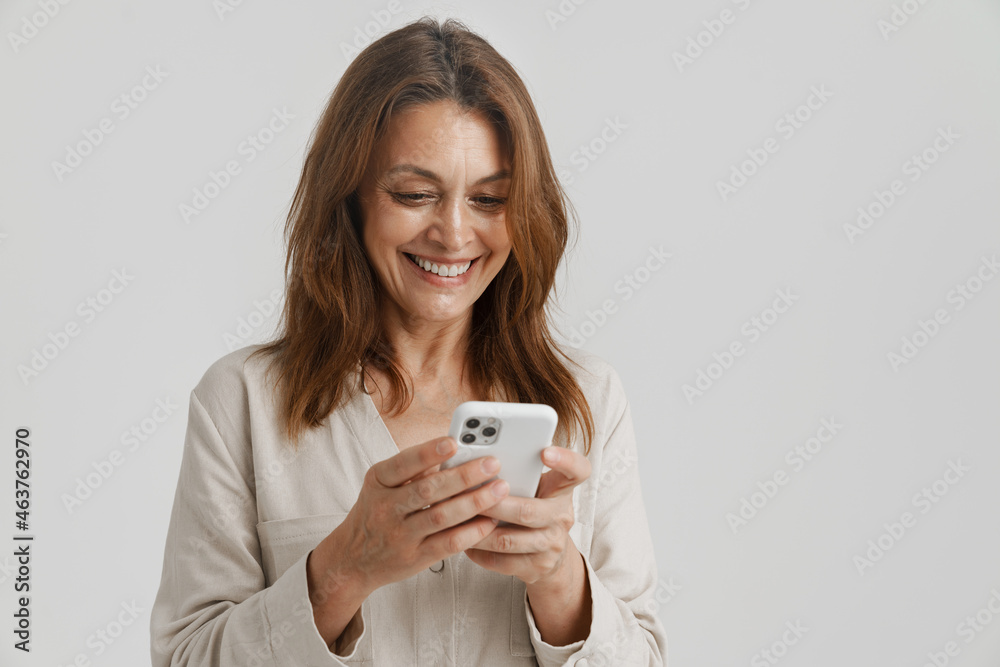 European ginger woman smiling while using mobile phone European ginger woman smiling while using mobile phone