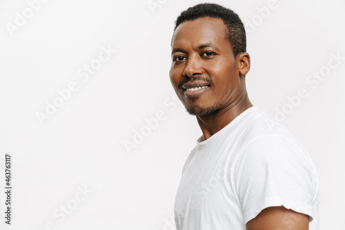 Black man wearing t-shirt smiling and looking at camera