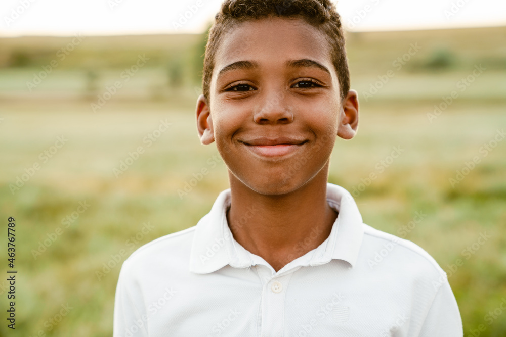 Black boy wearing white shirt smiling and looking at camera Black boy wearing white shirt smiling and looking at camera