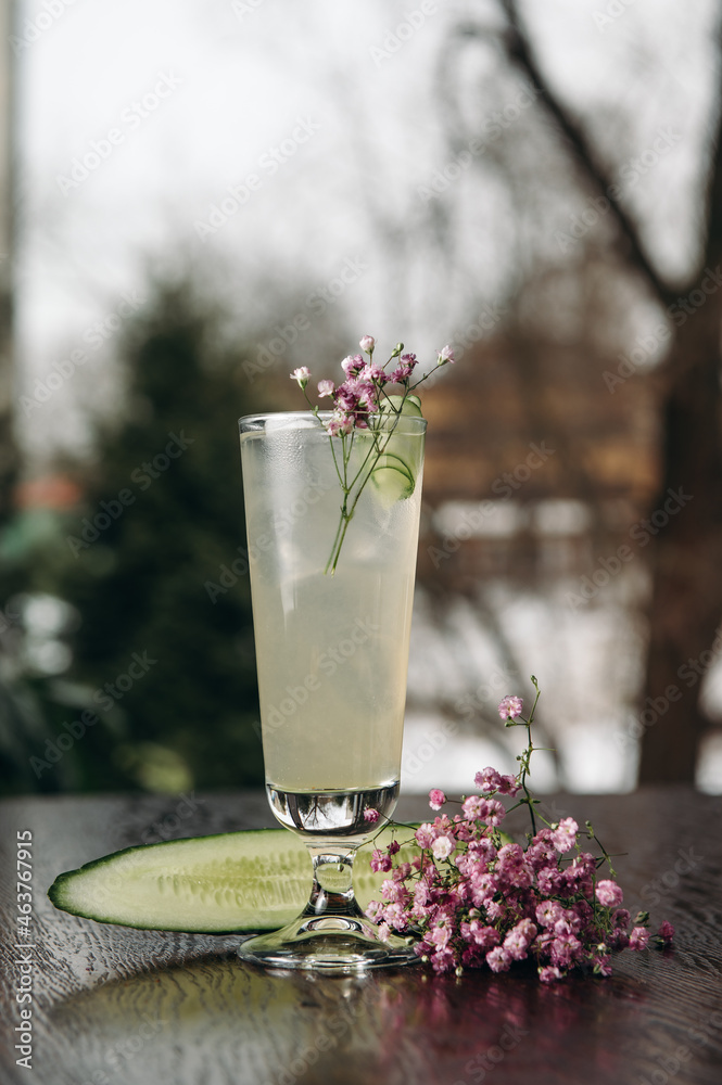 A refreshing glass of cucumber lemonade on a wooden table in a restaurant A refreshing glass of cucumber lemonade on a wooden table in a restaurant