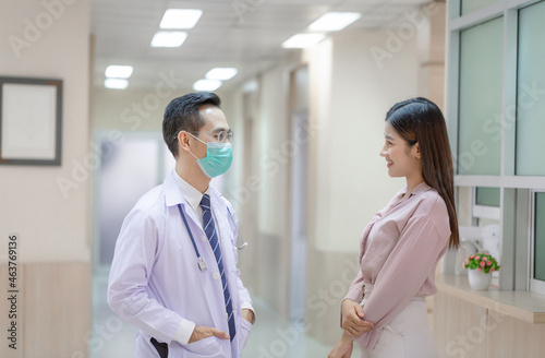 Doctor and patient discussing something while standing at a hospital. Medicine and health care concepts