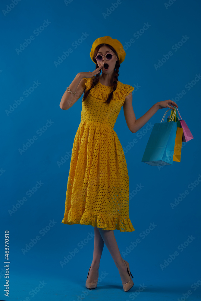 smiling woman in a yellow hat Shopaholic fashion style blue background