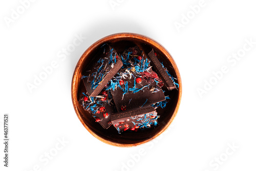 Dark chocolate with cherry, cranberry, pink pepper isolated on a white background. Chocolate pieces in wooden bowl.