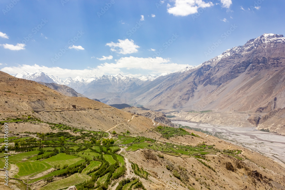 Beautiful landscape of Himalayan mountains above the green fields of the village of Dhankar in the Spiti valley in Himachal Pradesh, India.