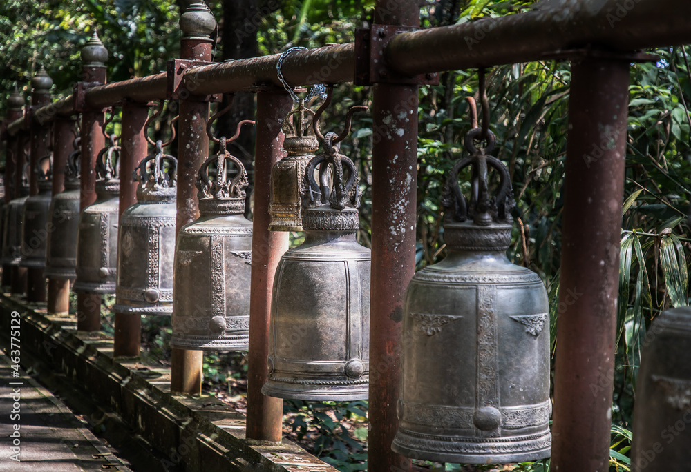 Many metallic bells hanging in a row on wooden pillars outside in thai buddhist temple. Lined with many beautiful bells, Thai temple bell which believe that who knock this bell will get the good luck, Many metallic bells hanging in a row on wooden pillars outside in thai buddhist temple. Lined with many beautiful bells, Thai temple bell which believe that who knock this bell will get the good luck,
