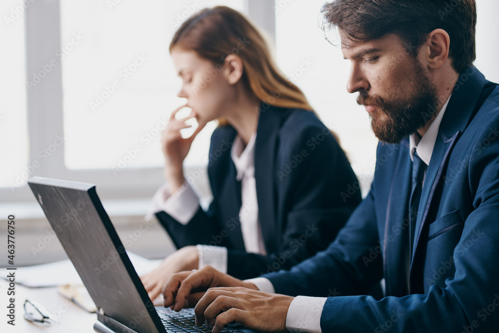 colleagues sitting at a desk with a laptop communication finance professionals colleagues sitting at a desk with a laptop communication finance professionals