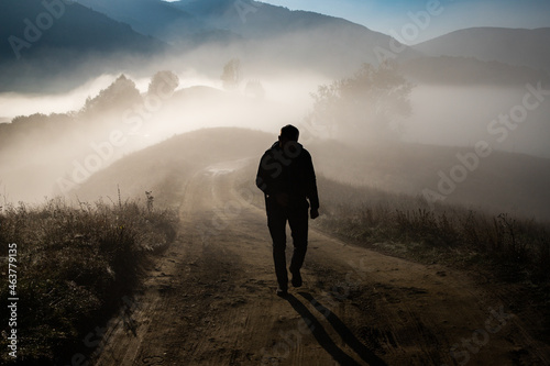 Schilderij op canvas man walking in a foggy autumn landscape