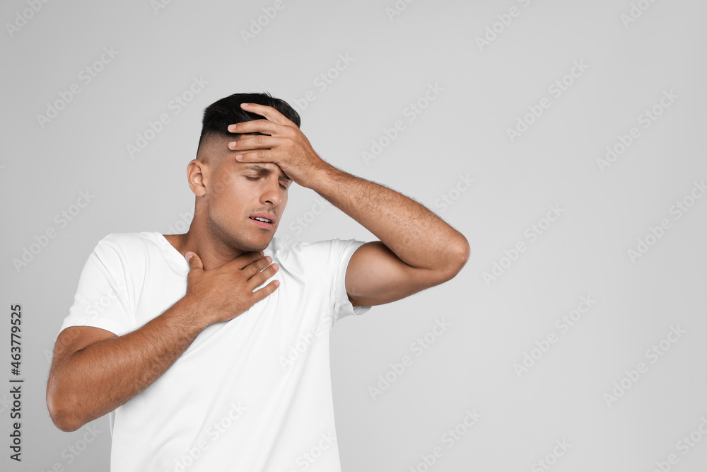 Man suffering from pain during breathing on grey background, space for text Man suffering from pain during breathing on grey background, space for text