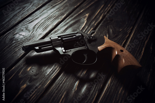 Revolver pistol on dark wooden background photo