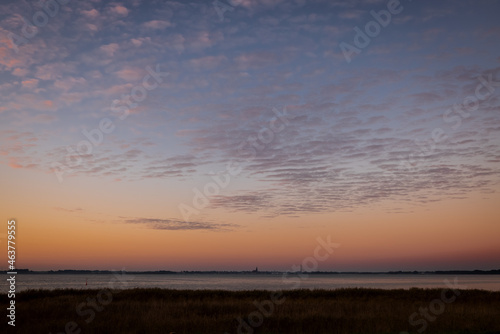 Sunrise wide sky over lagoon of Barth, with silhouette of church and town, Mecklenburg-Western Pomerania, Germany