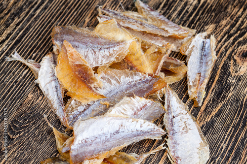 dried and butchered small fish on a wooden table © rsooll