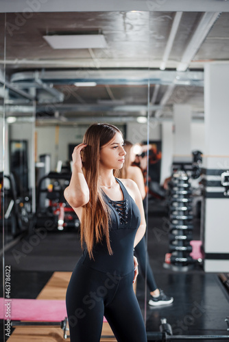 Healthy and fit woman in sport clothes posing at gym