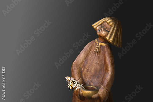 a girl like wooden sculpture against a dark background photo