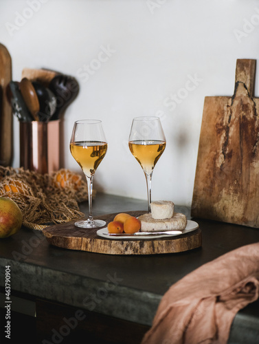 Two glasses of Orange Amber wine and appetizers on counter