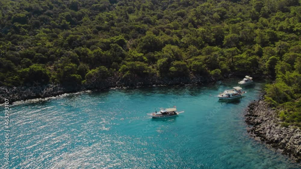 the yacht is moored in the turquoise harbor, Mediterranean Sea. people are swimming, Aerial view of yacht cruising. Aerial drone tracking sailing Motor Yacht boat on ocean. Fethiye, Muğla, Turkey the yacht is moored in the turquoise harbor, Mediterranean Sea. people are swimming, Aerial view of yacht cruising. Aerial drone tracking sailing Motor Yacht boat on ocean. Fethiye, Muğla, Turkey