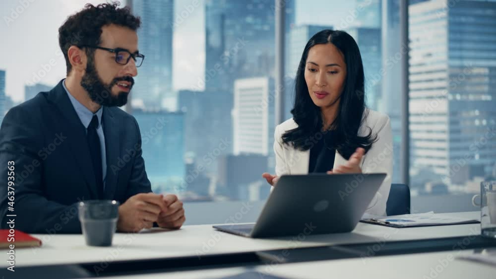 Businesspeople in Modern Office: Businesswoman and Businessman Use Laptop Computer, Talk. Top Manager and Partner Investor Discuss e-Commerce Software Global Investment Strategy. Elevating Wide Shot