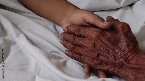 Worried man taking and gently stroking hand of  sick dad  showing care or love.