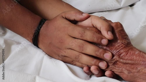 Worried man taking and gently stroking hand of  sick dad  showing care or love.