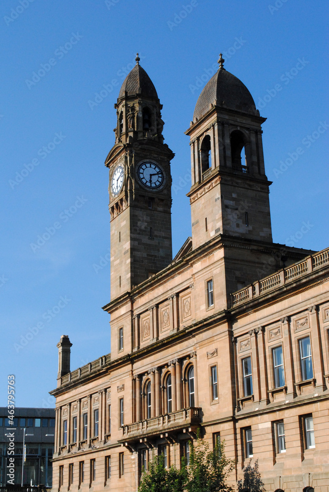 Twin Towers & Clock on Stone Public Building against Blue Sky 