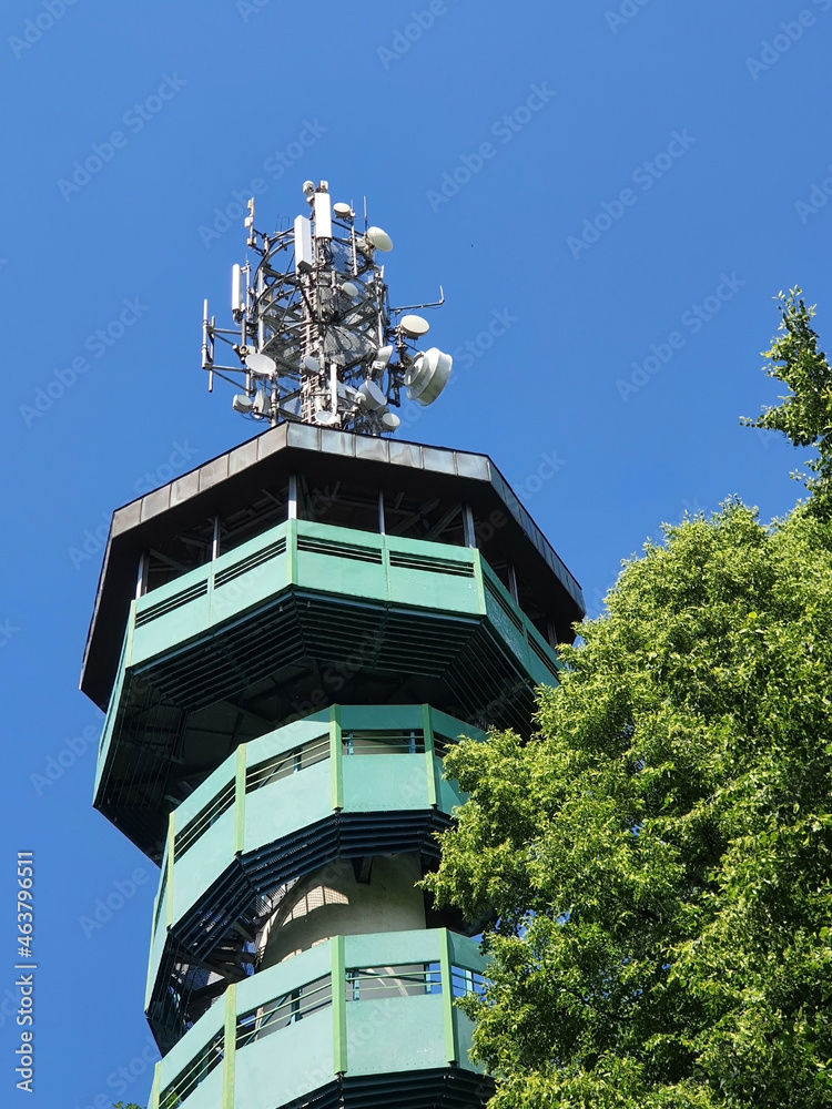 green tower in the woods with antennas and telephone equipment green tower in the woods with antennas and telephone equipment