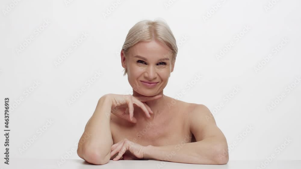 Aged Beauty. Attractive Mature Woman With Bare Shoulders Posing Over White Background Aged Beauty. Attractive Mature Woman With Bare Shoulders Posing Over White Background