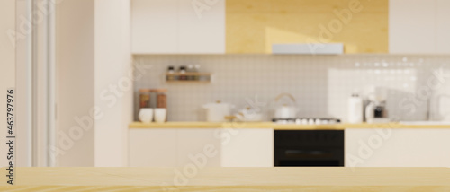 Wooden table top with mockup space over modern spacious bright kitchen space in background.
