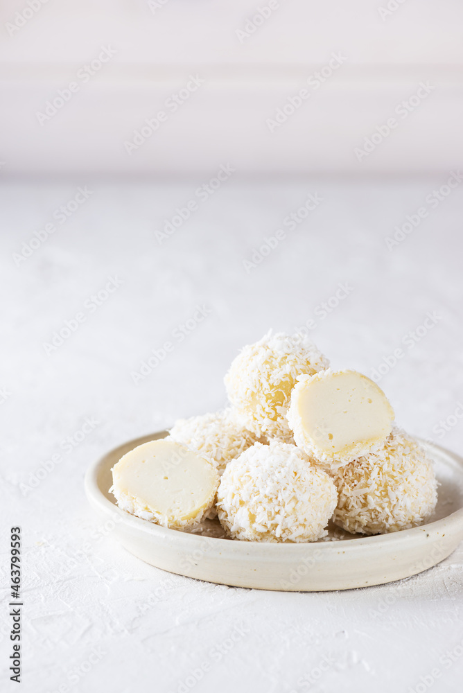 Sweet coconut truffles on a light background. Sugar, gluten and lactose free, vegan. Sweet coconut truffles on a light background. Sugar, gluten and lactose free, vegan.