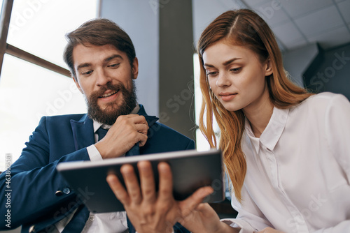 man and woman in business suits looking at the tablet officials teamwork