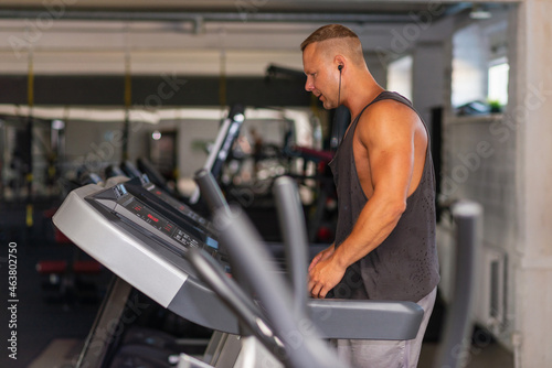 Young man in sportswear running on treadmill at gym.Handsome sport gym man running on the treadmill.Indoors shot.