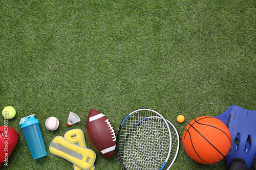 Fototapeta Naklejka Na Ścianę i Meble -  Different sport equipment on green grass, flat lay. Space for text