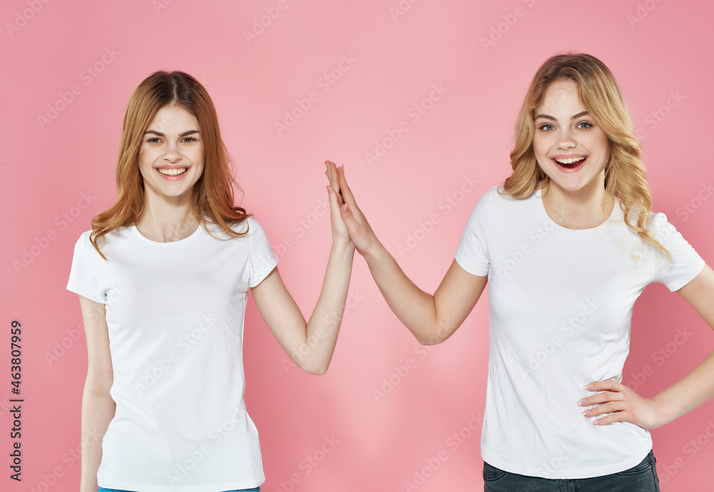 women in white t-shirts stand next to emotions friendship pink background women in white t-shirts stand next to emotions friendship pink background