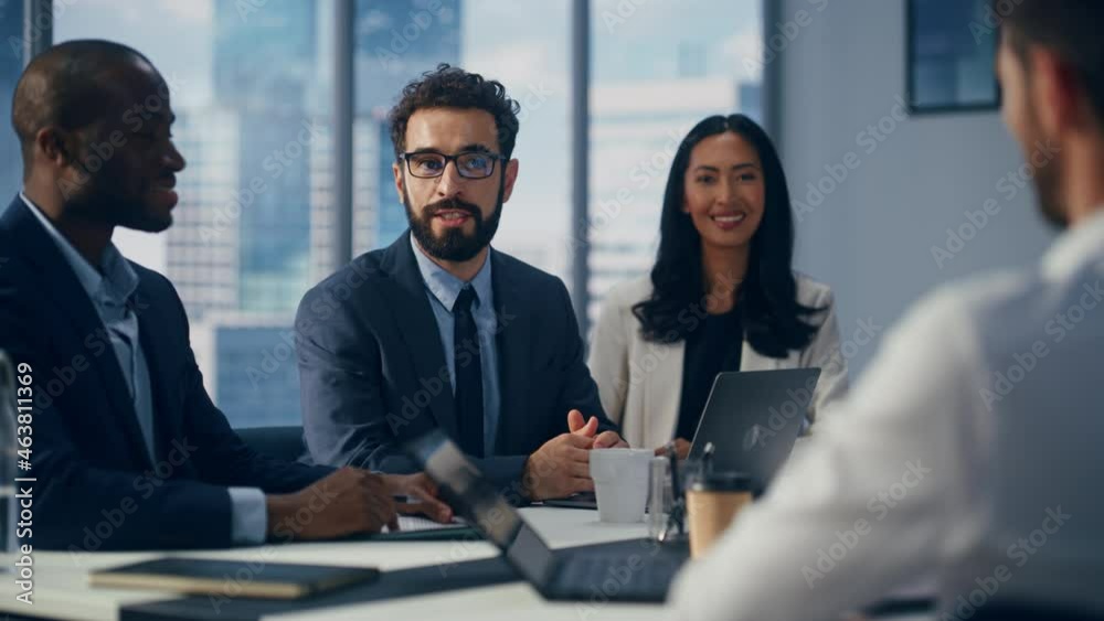 Modern Multi-Ethnic Office Conference Room Meeting: Diverse Team of Top Managers Talk, Brainstorm, Use Computers. Businessman Presenting Investment Strategy to Partners. Slow Motion Medium Close-up