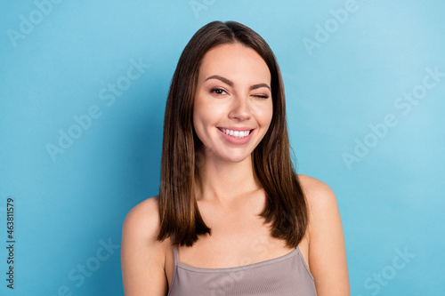 Photo of cute charming young woman dressed gray top smiling winking isolated blue color background
