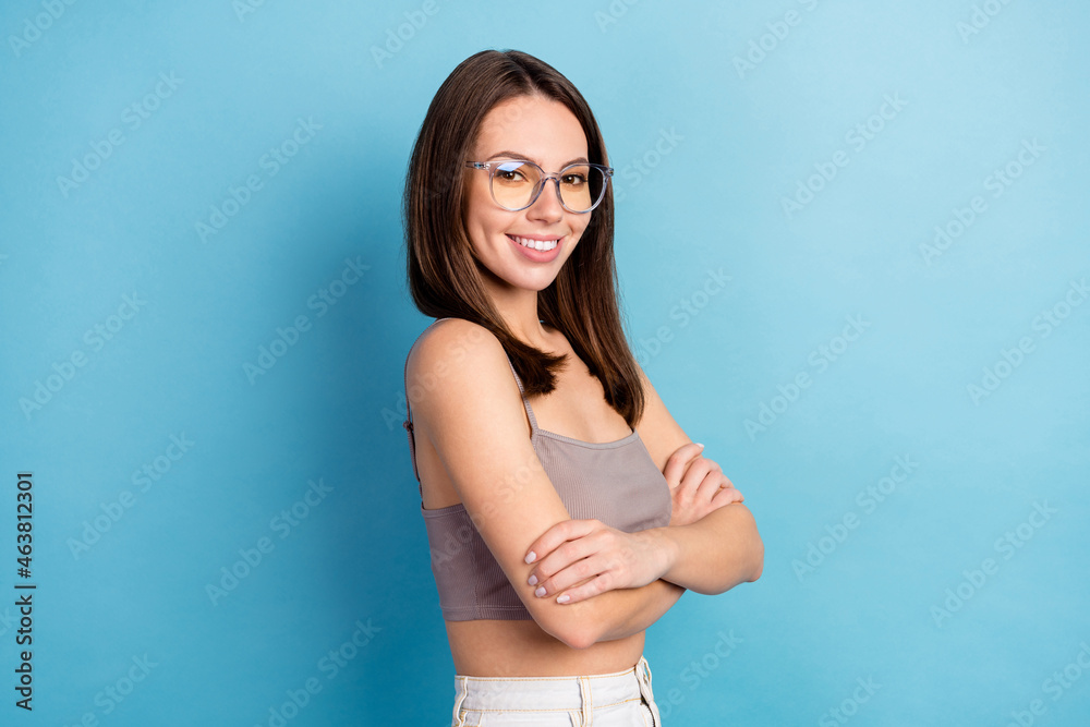 Photo portrait pretty woman wearing glasses crop top smiling folded hands isolated pastel blue color background Photo portrait pretty woman wearing glasses crop top smiling folded hands isolated pastel blue color background