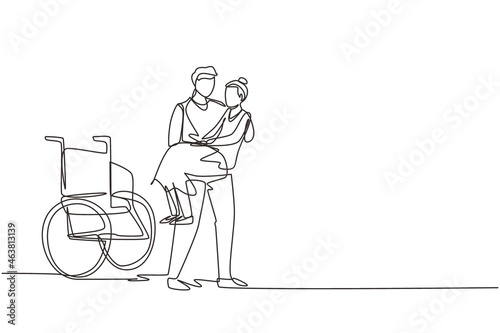 Single continuous line drawing loving son took his old disabled mother from wheelchair carrying her in his arms. Happy senior lady in hugs of her strong child. One line draw design vector illustration