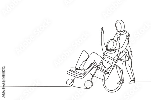 Single continuous line drawing young Arab female volunteer helps disabled old woman, riding on wheelchair in park. Family care, volunteerism, disability care. One line draw design vector illustration
