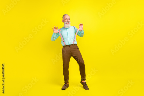 Full length body size photo gentleman wearing stylish outfit smiling dancing at party isolated vibrant yellow color background © deagreez