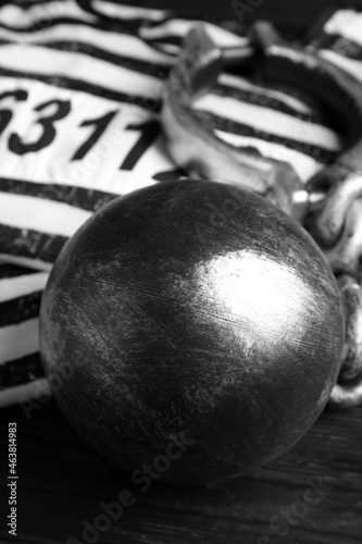 Prisoner ball with chain on black wooden table, closeup