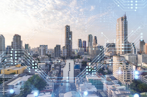 Glowing hologram of technological process  aerial panoramic cityscape of Bangkok at sunset. The largest innovative hub of tech services in Southeast Asia. Multi exposure.