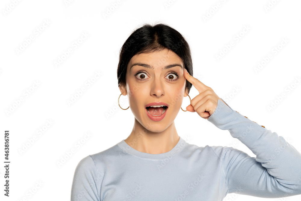 Young woman with finger pointing at her head, isolated on white. Young woman with finger pointing at her head, isolated on white.