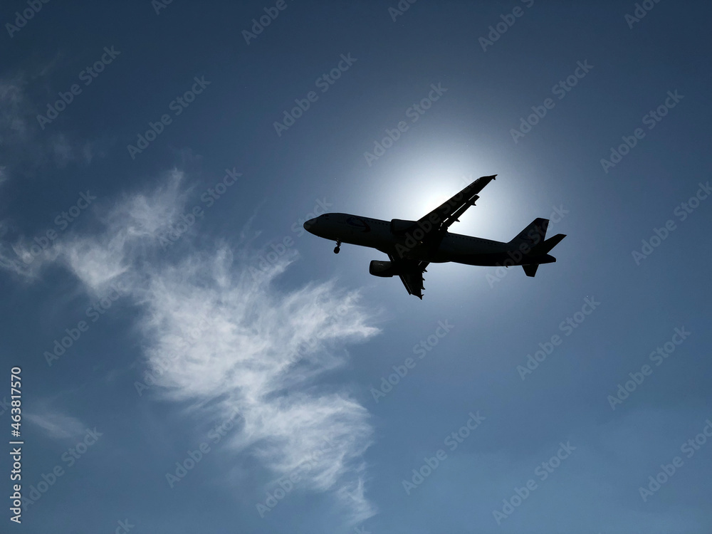 An airplane covering the sun against a blue sky An airplane covering the sun against a blue sky