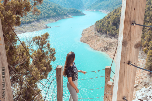 Shot of a young girl standing on a wooden platform at Congost de Mont-Rebei in Lleida, Spain photo