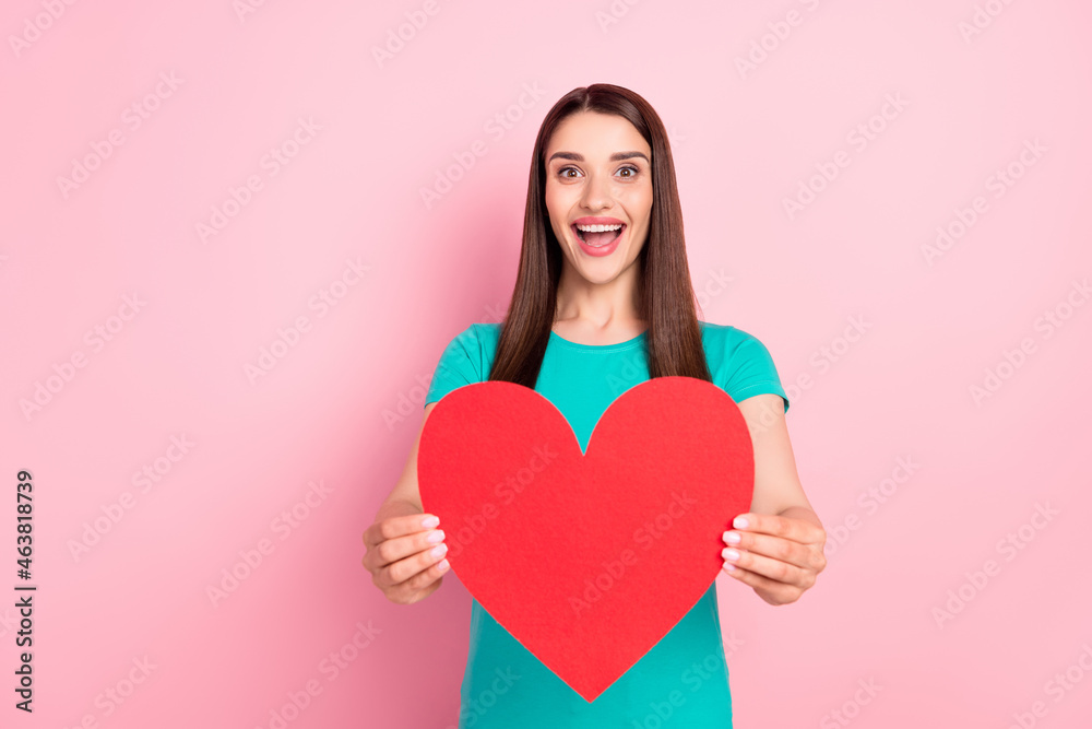 Photo of young cheerful woman happy positive smile show paper heart card romance feelings isolated over pink color background Photo of young cheerful woman happy positive smile show paper heart card romance feelings isolated over pink color background