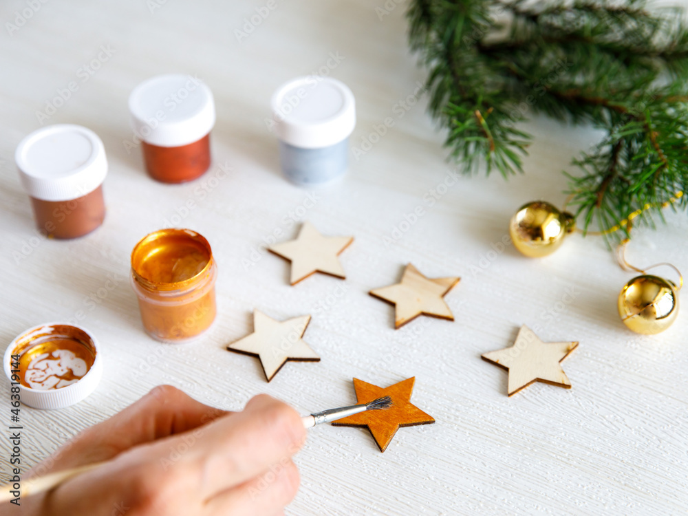 The process of painting wooden Christmas decoration - five stars. Decoupage process. Preparation for New year or Christmas concept background. Selective focus, top view The process of painting wooden Christmas decoration - five stars. Decoupage process. Preparation for New year or Christmas concept background. Selective focus, top view