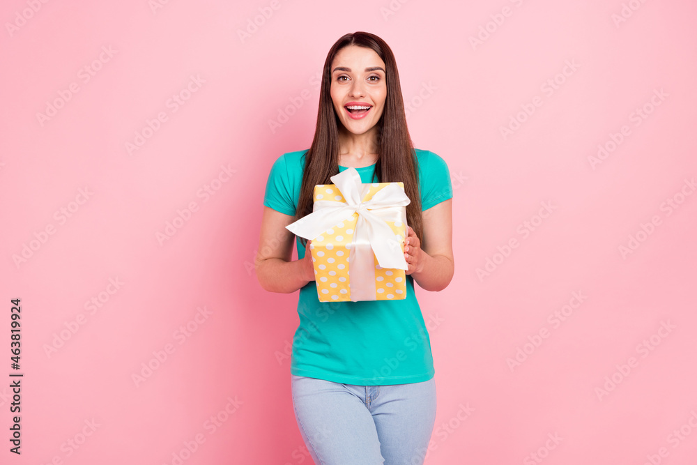 Photo of young attractive woman happy positive smile hold present box birthday isolated over pastel color background Photo of young attractive woman happy positive smile hold present box birthday isolated over pastel color background