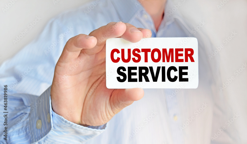 Business man holding a business card. The content of the lettering has implications for business concept and marketing.